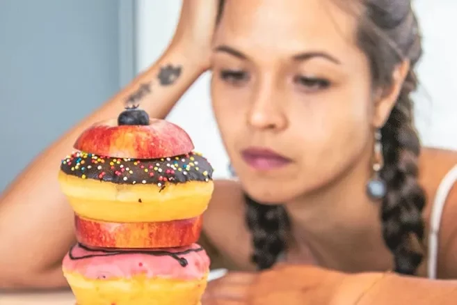 Frau isst genussvoll einen Donut-Turm